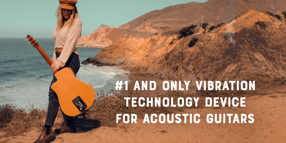 Guitarist walking a coastal trail with a ToneWoodAmp2-equipped acoustic guitar